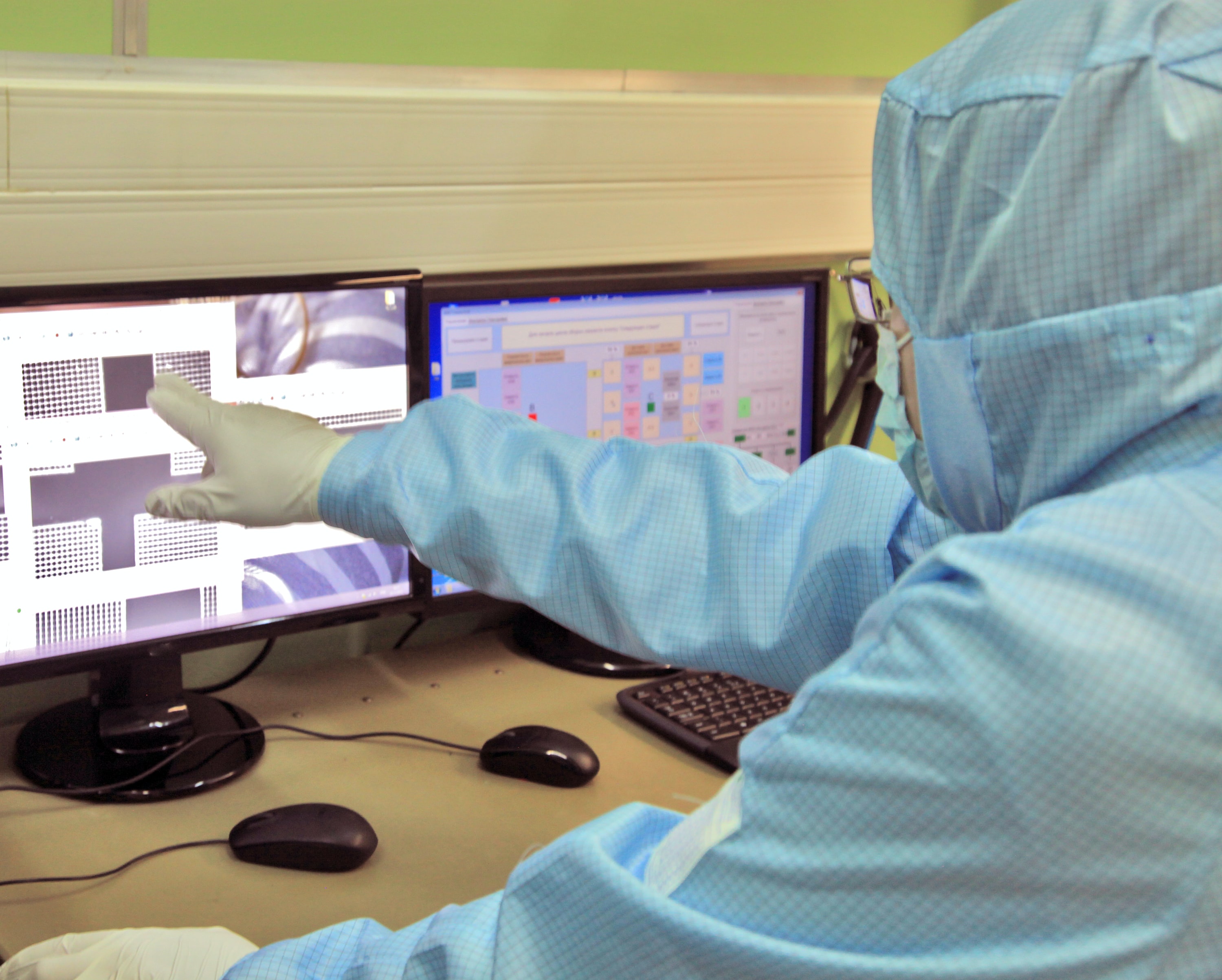 gloved researcher pointing at computer screen